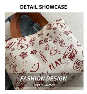 Close-up of graffiti print tote bag with brown handles and trendy artistic patterns