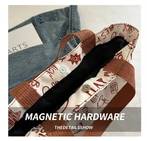 Detail view of the metal magnetic clasp and durable canvas texture on the tote bag