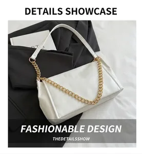 Detail view of white leather bag with luxury golden chain link and textured surface