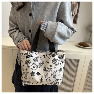 Close-up of canvas tote bag featuring urban graffiti prints and blue checkered lining