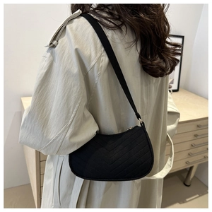 Detail of black crescent shoulder bag featuring V-shaped quilting and matte texture