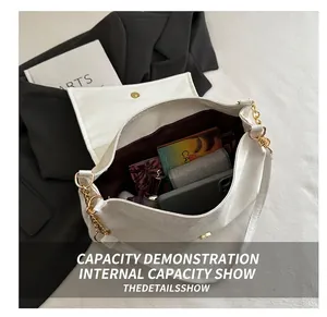 Interior view of white crocodile pattern square bag showing storage capacity for phone and makeup