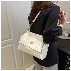 Detailansicht der weißen Schultertasche mit goldener Schnalle und Kettenträger