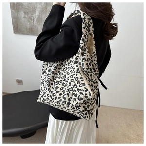 Détail du sac cabas en velours côtelé léopard et sa pochette assortie sur l'épaule
