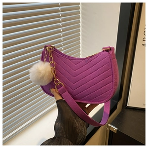 Detail of purple chevron quilted hobo bag with gold chain and white faux fur pompom