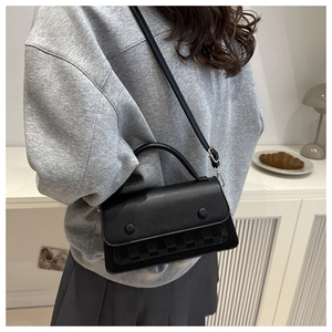 Detail of black PU leather shoulder bag with checkerboard pattern and adjustable strap