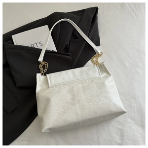 Detail of white faux snakeskin shoulder bag with premium gold chain and stylish texture