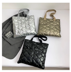 Gros plan de sacs cabas matelassés en argent, or et noir avec finition métallique