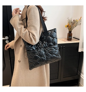 Vue portée du grand sac fourre-tout noir matelassé avec texture à motif de losanges