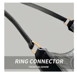 Detail shot of the golden metal ring connector on a black minimalist shoulder bag strap