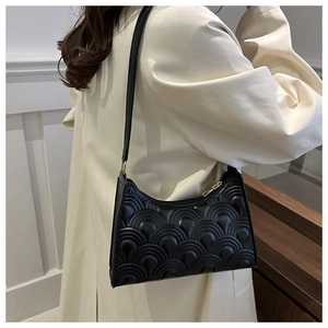 Detail of black underarm bag with 3D wave pattern texture on a beige coat background