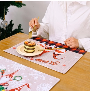 Close-up of Christmas gnome placemat with red buffalo plaid on a wooden dining table