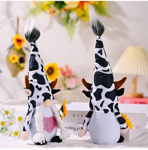 Detail of cow-themed gnome plush toys with sequin heart and sunflower decor