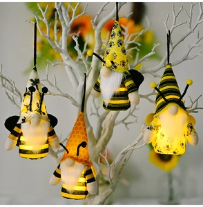 Dettaglio di quattro gnomi ape luminosi con LED caldi su rami decorativi bianchi