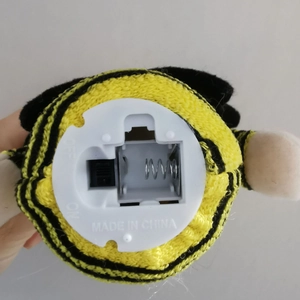 Detail of the battery compartment and power switch on the bee gnome plush toy