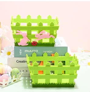 Detail of green felt Easter basket with pink rabbit and flower decorations on pink background