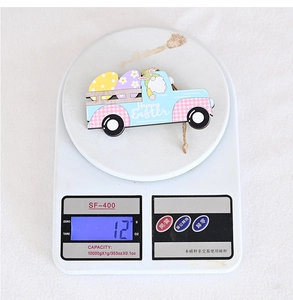 Detailed view of an Easter wooden truck hanging ornament weighing 12g on a scale