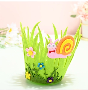 Close-up of green felt Easter basket with colorful flowers and a cute snail detail