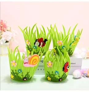 Detail of green felt Easter baskets with snail and butterfly patches on pastel background
