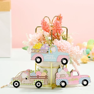 Three Easter wooden truck ornaments with gnomes and eggs hanging on a pink background