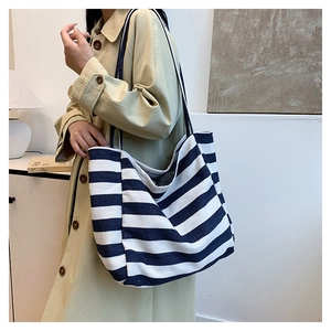 Detail of navy blue and white striped canvas tote bag showing texture and shoulder strap