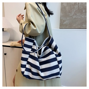 Detail of blue and white striped canvas tote bag showing thick texture and wide strap