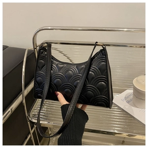 Close-up of black quilted baguette bag with gold-tone hardware and elegant PU leather texture