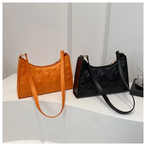 Detail view of scalloped shell texture on orange and black minimalist hobo shoulder bags