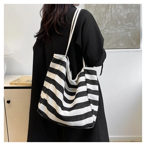 Minimalist black and white striped canvas tote bag worn by a model in a modern room