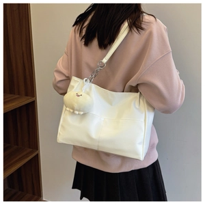 Sac fourre-tout blanc avec chaînes argentées et pendentif en peluche sur un mannequin