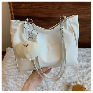 Détail du grand sac cabas blanc en cuir avec bandoulière chaîne et pendentif en peluche