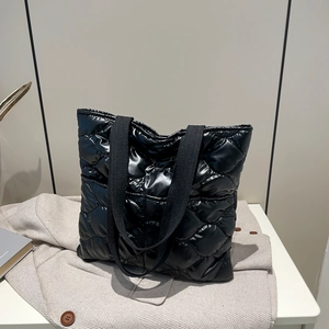 Chic black quilted puffer tote bag with glossy finish and soft fabric shoulder straps
