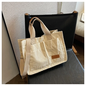 Fashionable beige corduroy tote bag with dual front pockets and adjustable shoulder strap