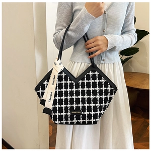 Detail of checkered tote bag featuring V-cut opening and elegant decorative ribbon bow