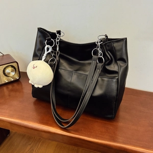 Sac fourre-tout chic en cuir noir avec bandoulière en chaîne et charme en peluche