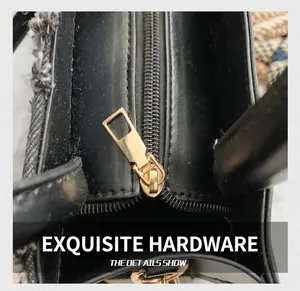 Macro shot of light gold metal zipper puller and tweed detail on black leather bag