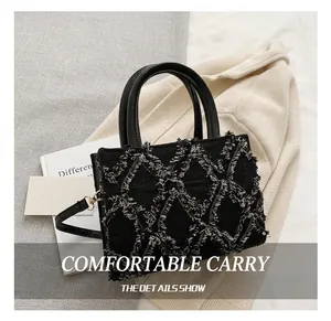 Close-up of black denim handbag featuring distressed diamond quilted stitching details