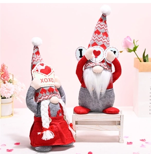 Detail of plush Valentine Gnomes with XOXO envelope and heart signs on pink background