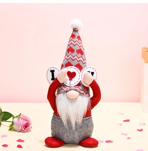 Detail of plush Valentine gnome with red zig-zag hat holding an I Love U heart sign