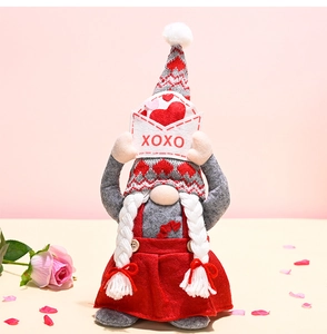 Detail of Valentines gnome plush holding XOXO envelope with heart knit hat and braided beard