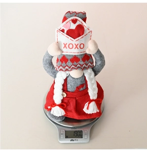Valentine gnome plush toy weighing 190g on a digital scale with XOXO envelope detail