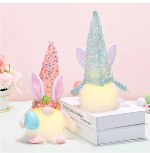 Detail beleuchteter Oster-Gnome mit Paillettenhüten und Hasenohren auf Büchern