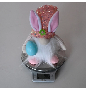 Gewichtsmessung eines leuchtenden Oster-Gnomes mit rosa Paillettenhut und Hasenohren