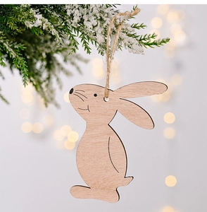 Close-up of wooden Easter rabbit pendant hanging on pine branch with warm bokeh