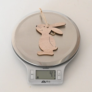 Close-up of lightweight wooden Easter bunny ornament weighing 4.1g on a scale