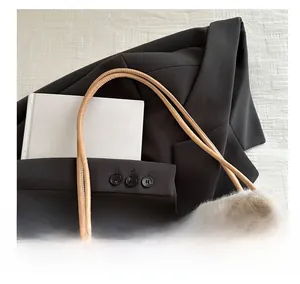 Detail view of plush faux fur tote bag with slim leather handles on a dark blazer