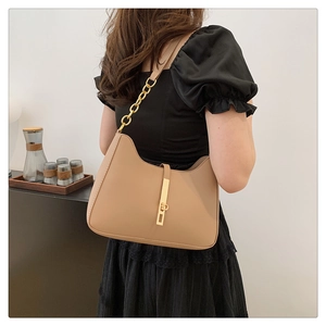 Detail der kamelfarbenen Halbmond-Handtasche mit goldener Kette und Metallverschluss