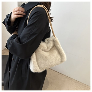 Creamy beige plush tote bag on shoulder with soft faux fur texture for winter