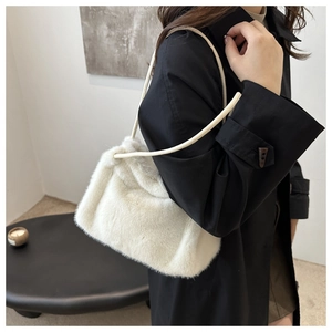 Detail shot of the white faux fur texture on a minimalist winter plush shoulder bag