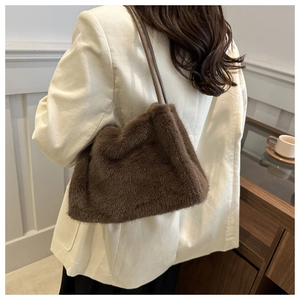 Detailed view of brown plush tote bag with fluffy texture on model's shoulder